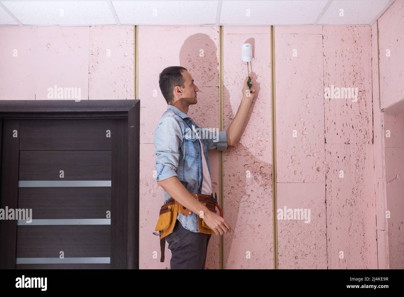 Young Male Technician Installing Security System Stock Photo