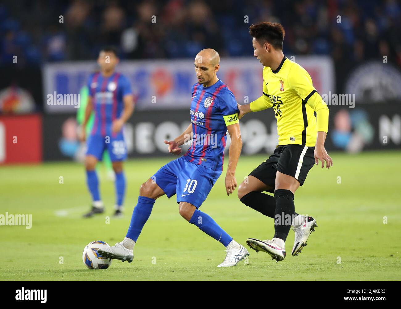 Leandro Velazquez of Johor Darul Ta'zim (L) and He Shaolin of Guangzhou Evergrande are seen in action during the AFC Champions League Group I match between Guangzhou Evergrande and Johor Darul Ta'zim at the Sultan Ibrahim Stadium.(Final score; Guangzhou Evergrande 0:5 Johor Darul Ta'zim) Stock Photo