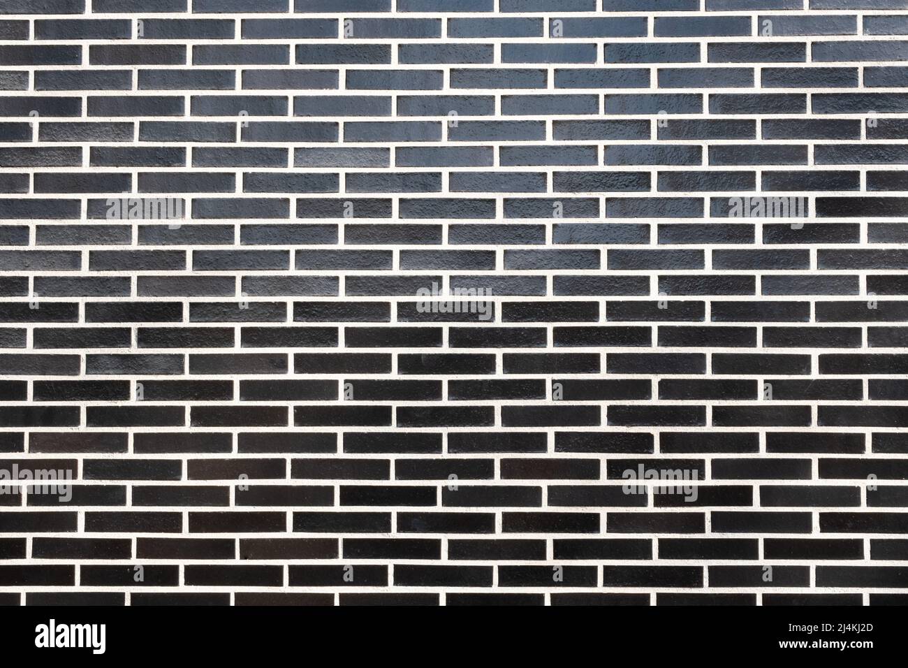 A black brick wall texture with white grout, horizontal orientation. Great seamless background for different purposes, copy space for text. Stock Photo