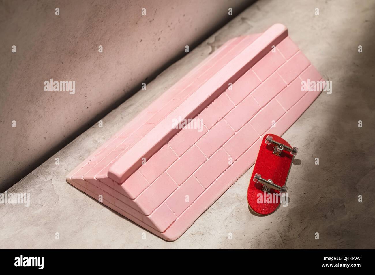 Pink plaster ramp and fingerboard on an abstract background Stock Photo ...