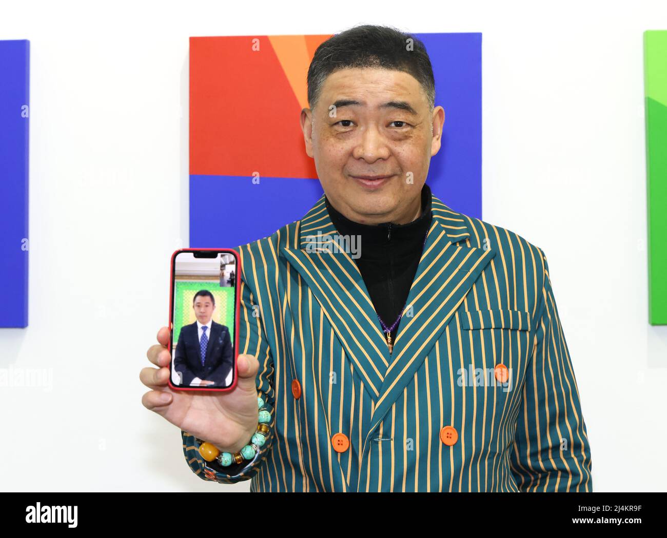 Santa Monica, California, USA. 14th April, 2022. Artist Xinyong Wang (by video conference) with TV host Joey Zhou attending the opening of PSJM's 'American Democracy' art exhibition at Building Bridges Art Exchange at Bergamot Art Center in Santa Monica, California. The art exhibition featured 59 paintings, each representing the election year of a United States president and the historical results of each political party (red = Republican, blue = Democratic, etc.) displayed in a geometric format. Credit: Sheri Determan Stock Photo