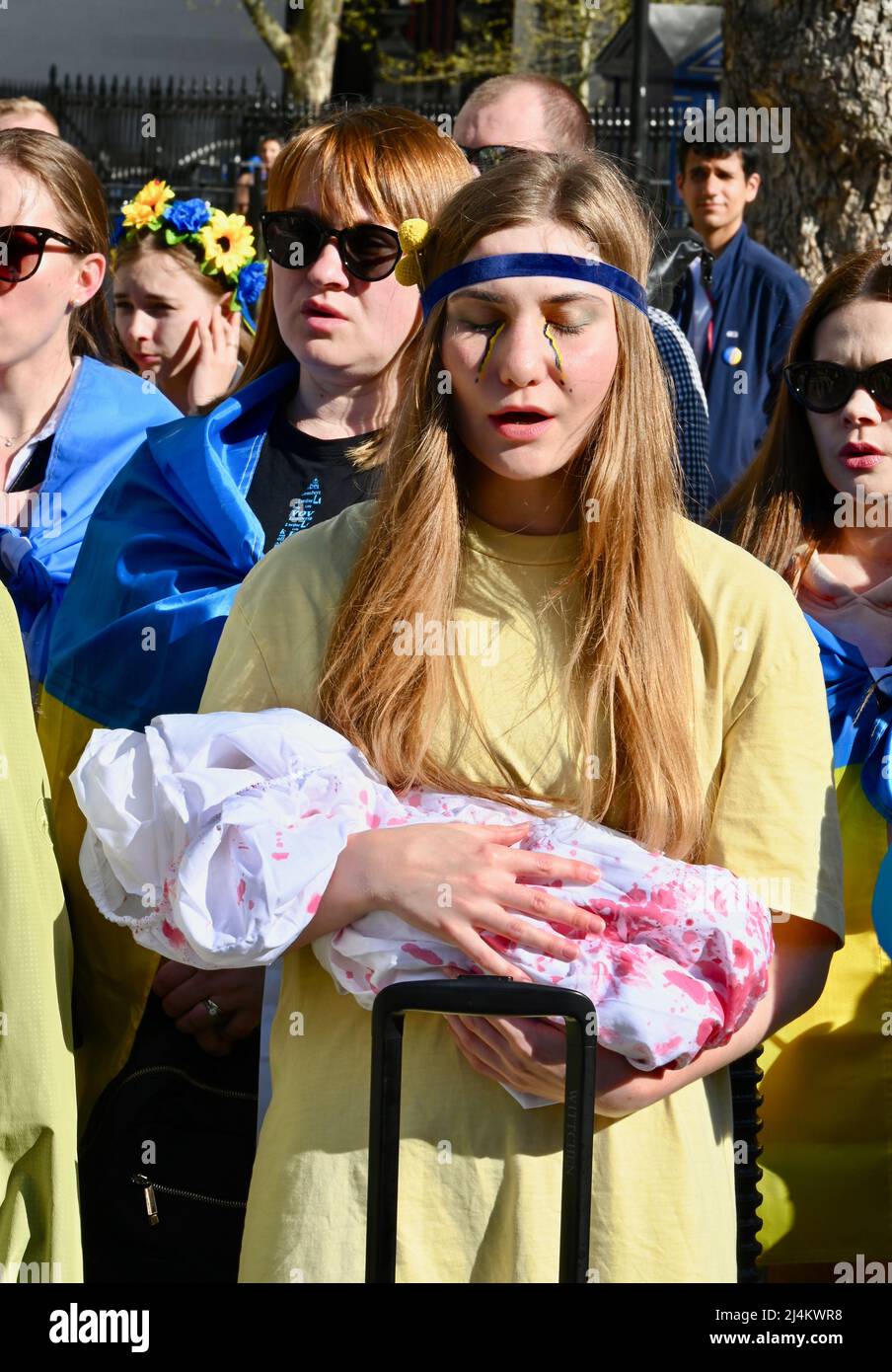 London, UK. 16th Apr 2022. A young woman holds a "baby" covered in fake  blood to illustrate the horrors of the conflict. Members of the Ukrainain  Community attended a rally opposite Downing