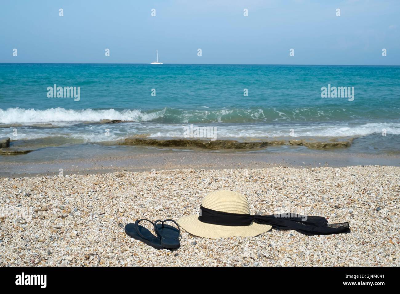 Flip flops and straw hat on the beach Stock Photo - Alamy