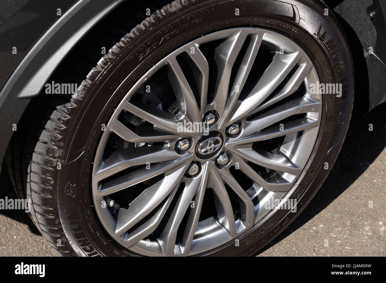Stock photo closeup of a silver coloured alloy wheel rim with a multi spoke wheel style on a 2021 Toyota CH-R with dark grey metallic paint. UK Stock Photo