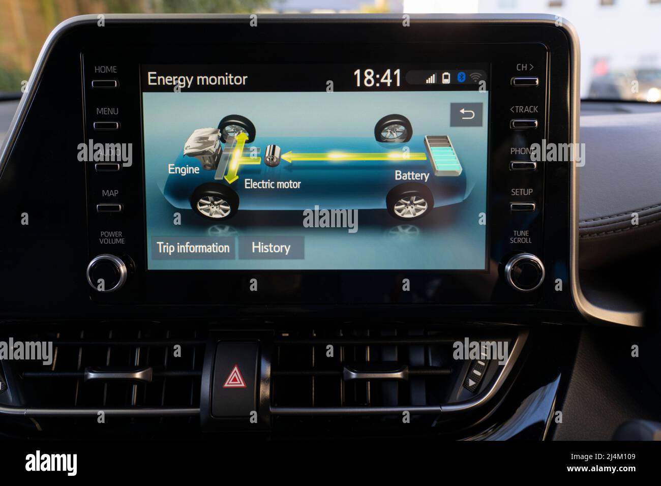 Screen in a petrol self charging hybrid Toyota CH-R car showing the interaction between the internal combustion engine, electric motor and battery Stock Photo