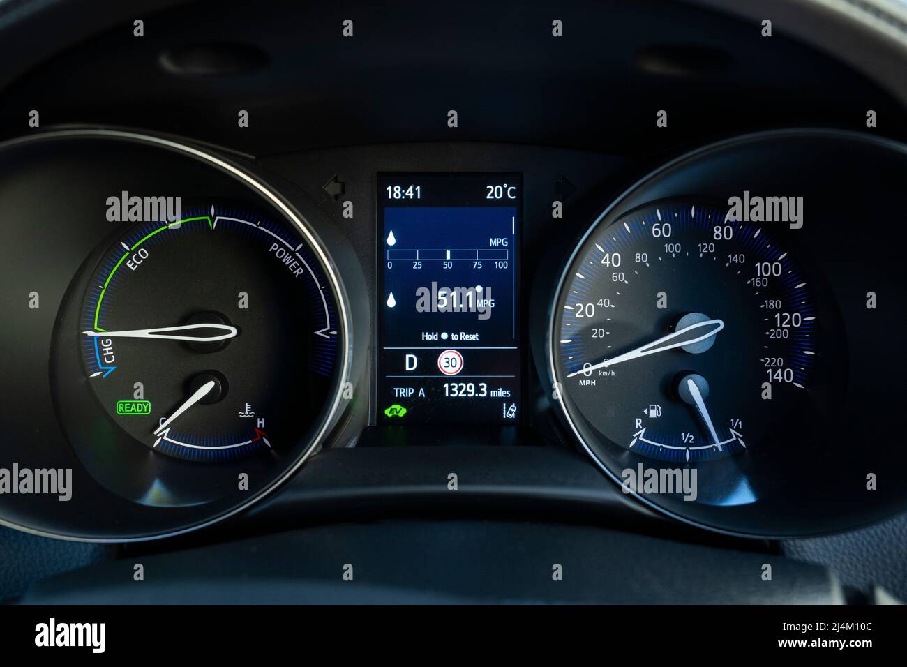 A self charging hybrid dashboard instrument panel showing the car fuel efficiency in mpg and that EV (electric vehicle) mode is on. Toyota CHR. UK Stock Photo