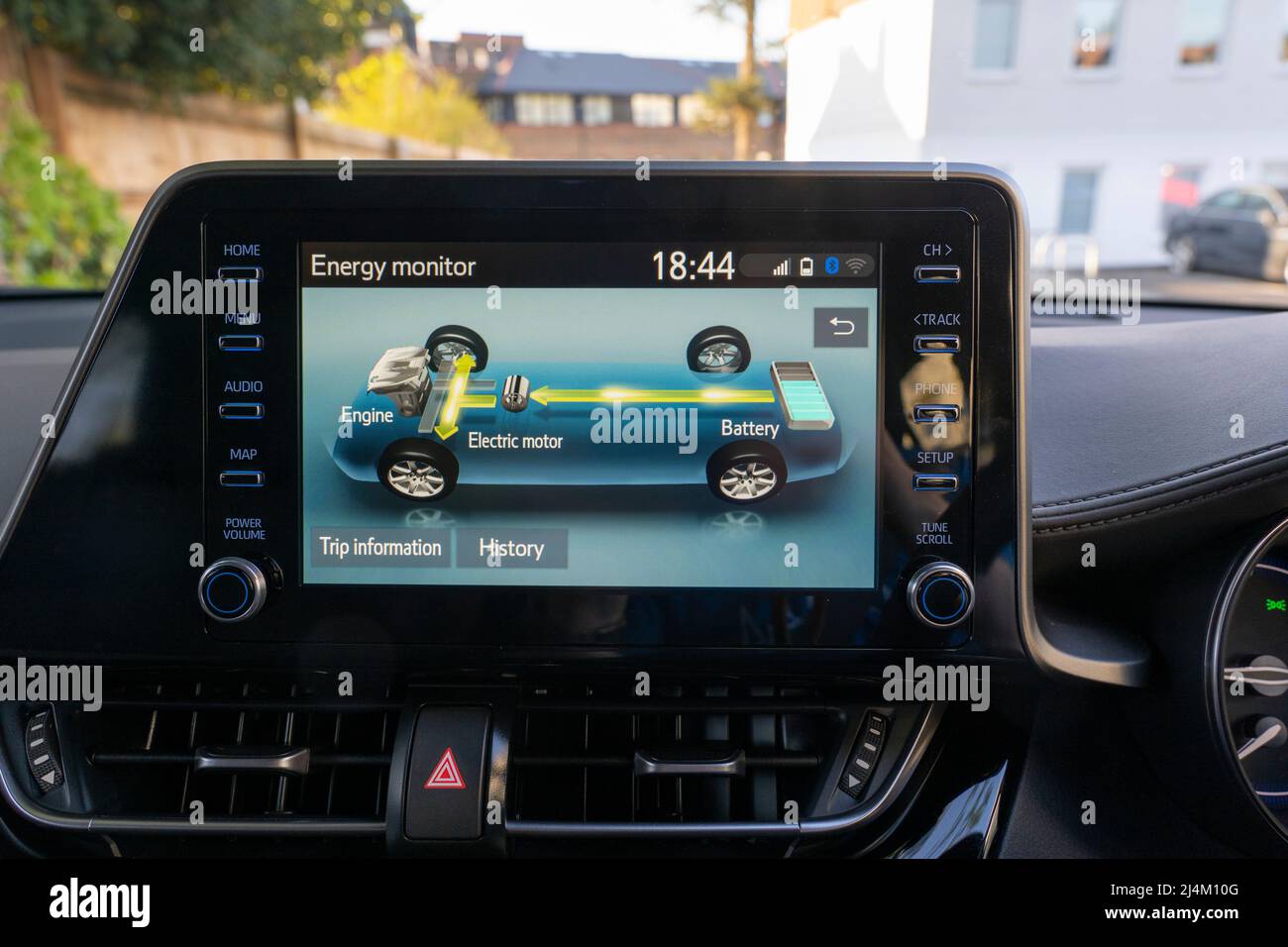 Screen in a petrol self charging hybrid Toyota CH-R car showing the interaction between the internal combustion engine, electric motor and battery Stock Photo
