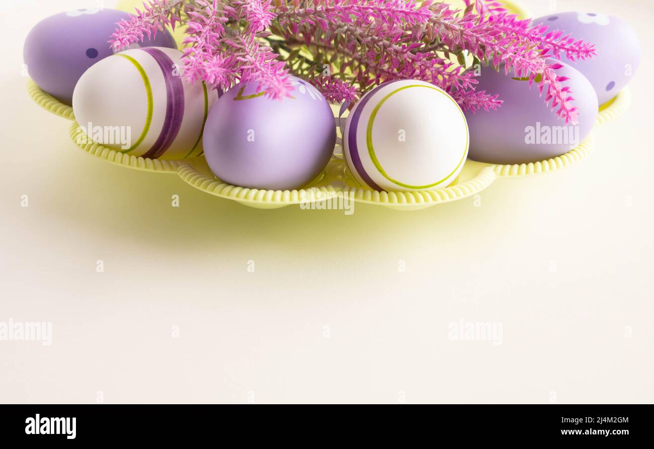 Easter concept lilac Easter eggs with a branch of artificial lavender on a light background. Place for your text. Stock Photo