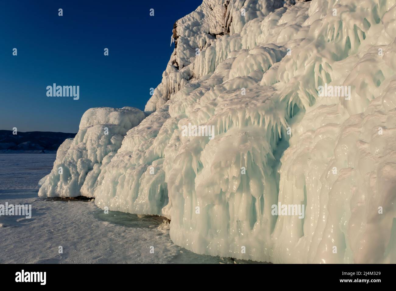 Ice and icicles on rocks on Lake Baikal Stock Photo