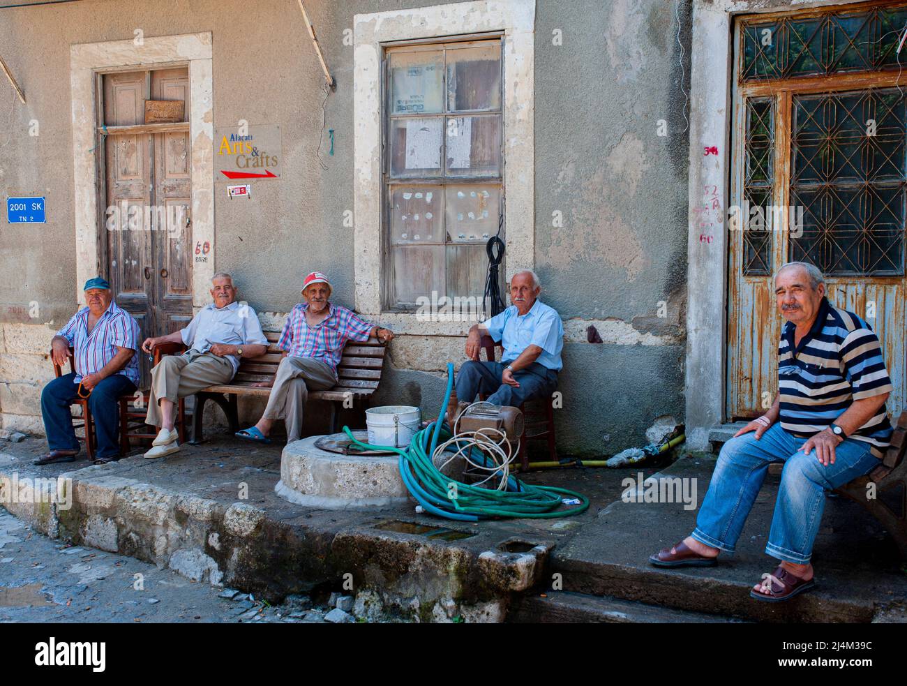 Turkish men sit together having a morning chat and conversation about life and the new day in Alaçatı, Turkey. Stock Photo