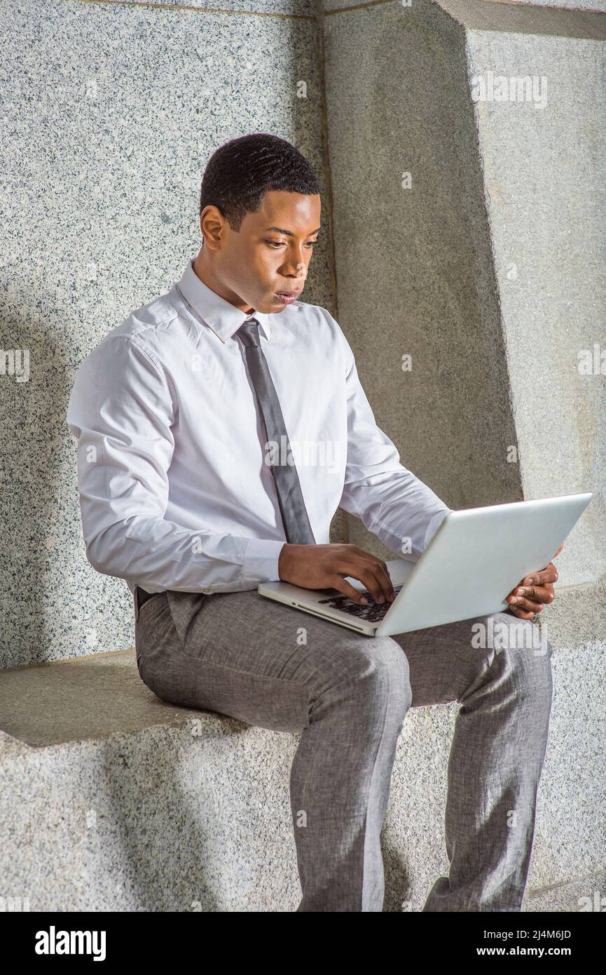 white shirt, a black tie, gray pants 