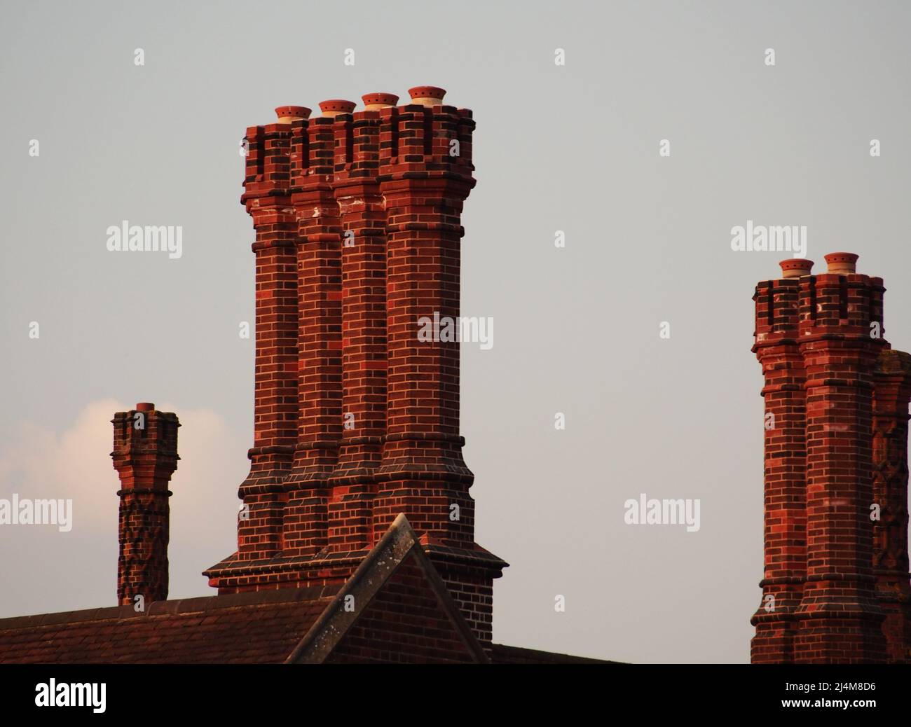 A view of some of the red brick, ornate chimneys of Hampton Court Palace, London, Surrey, England, the home of King Henry VIII Stock Photo