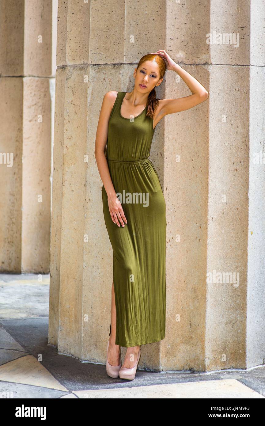 Dressing in a green Maxi Tank Dress, creamy high heels, crossing legs, one  hand touching her head, one hand resting on her thigh, a young fashion bla  Stock Photo - Alamy