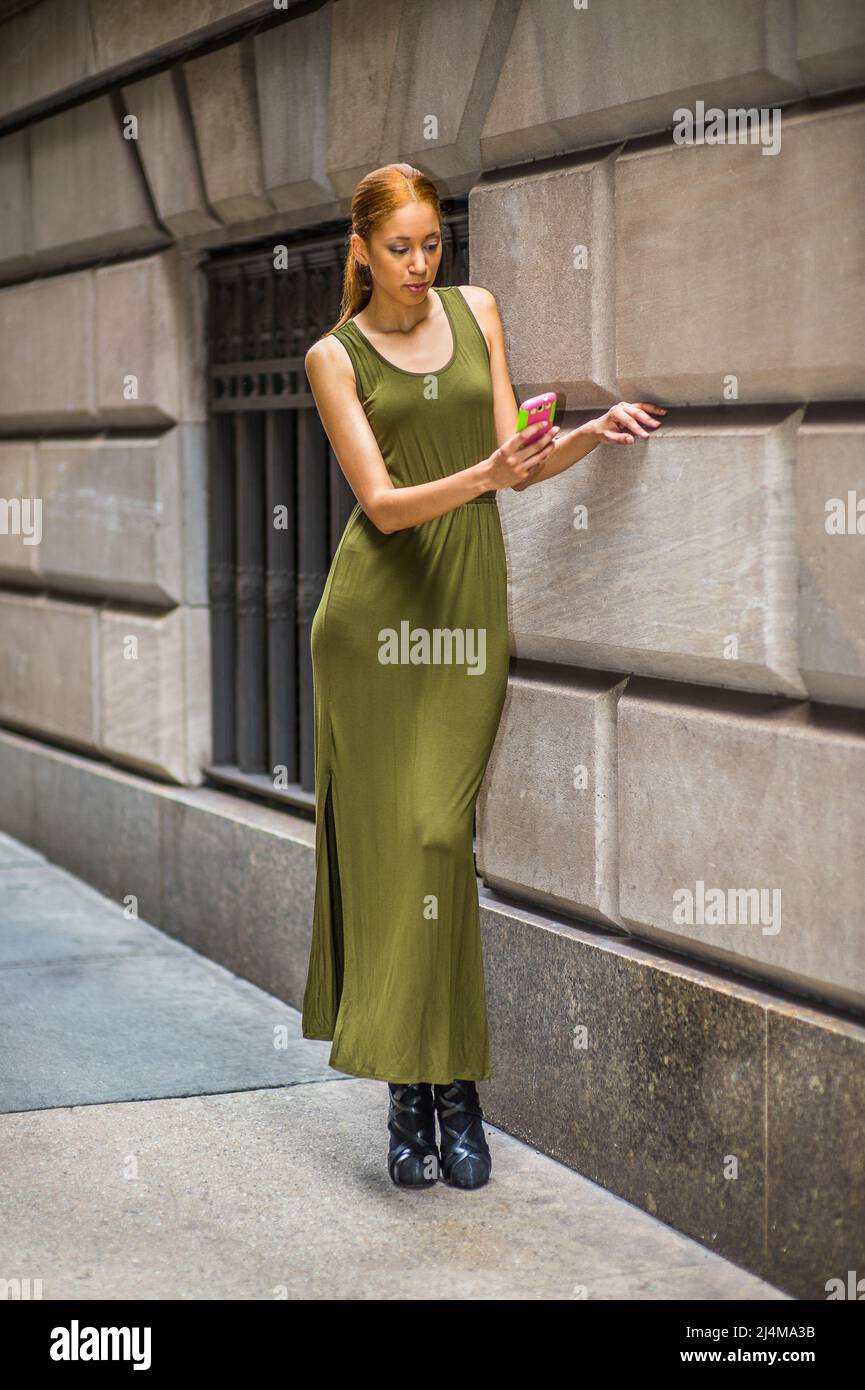 Woman texting on street. Dressing in a green, long Maxi Tank Dress, dress  sandals, a young black lady is standing by old fashion style window and  wall Stock Photo - Alamy