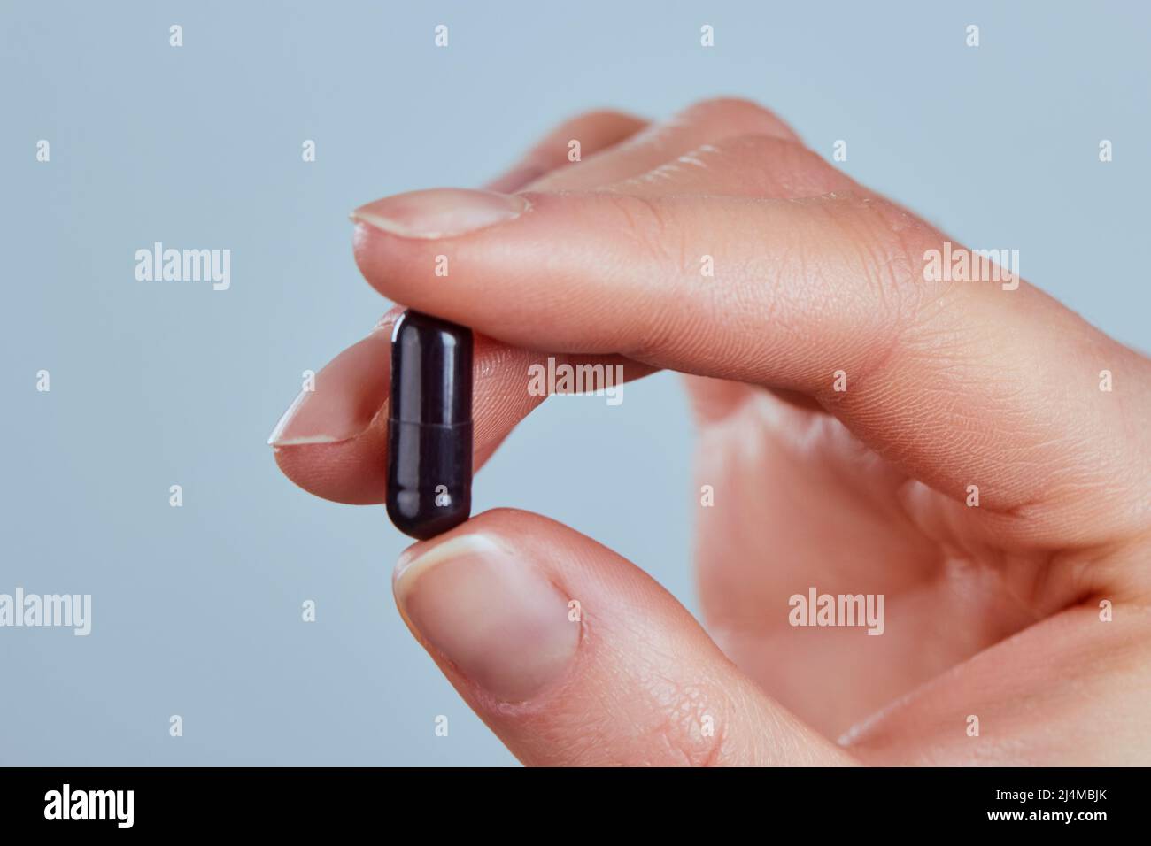 Vitamins And Dietary Supplements. Woman Holding Vitamin Pill In Hand