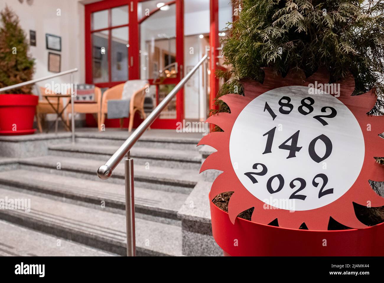 Pot plant with anniversary celebration sign at entrance of chalet restaurant Stock Photo