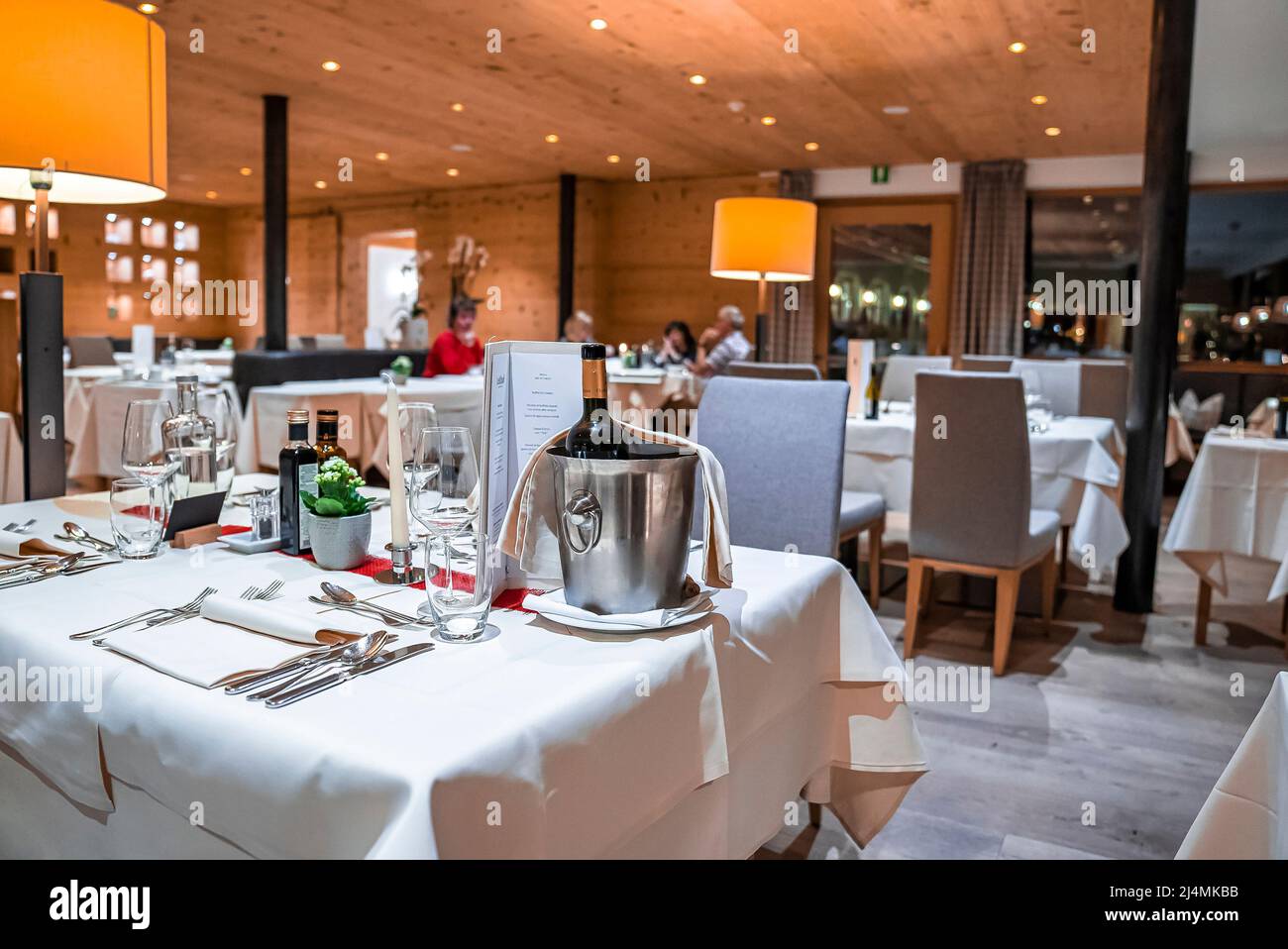Wine bottle in ice bucket on table with elegant place setting in luxury