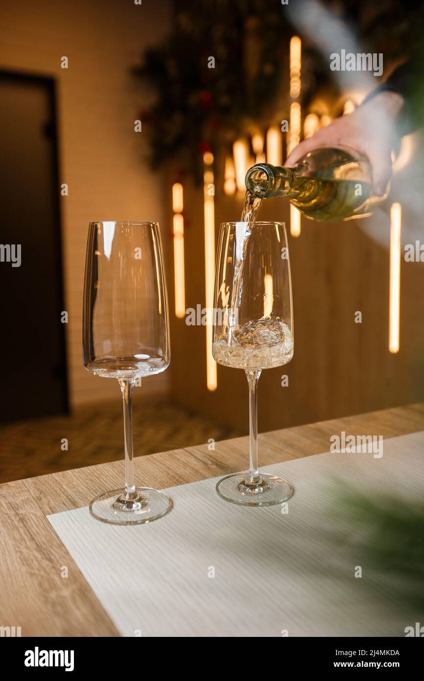 https://c8.alamy.com/comp/2J4MKDA/dispensing-golden-white-wine-into-two-wineglasses-in-a-close-up-on-the-neck-of-the-bottle-over-wood-with-copy-space-in-a-tilted-angle-view-2J4MKDA.jpg