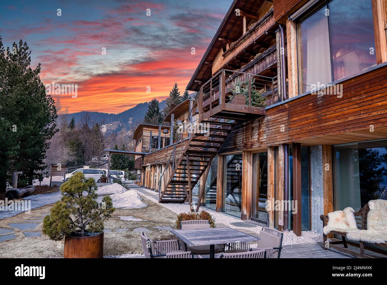Beautiful wooden chalet hotel on slope of mountain during winter season Stock Photo
