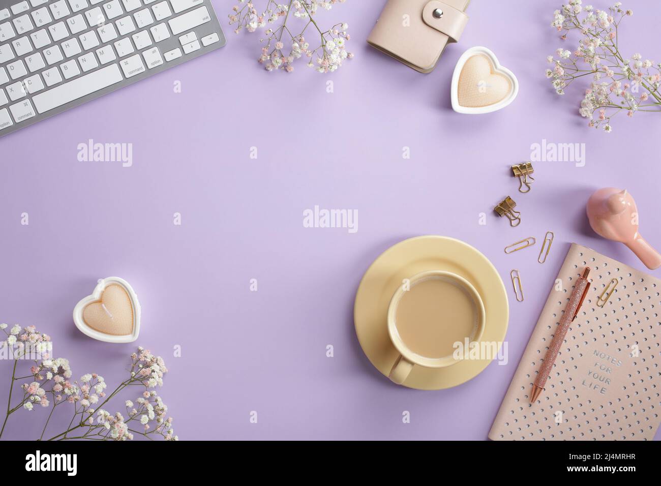 Cozy feminine desk table with keyboard, coffee cup, heart shaped candles,  pink notebook, office stationery, spring flowers on pastel purple  background Stock Photo - Alamy, image size:1300x956