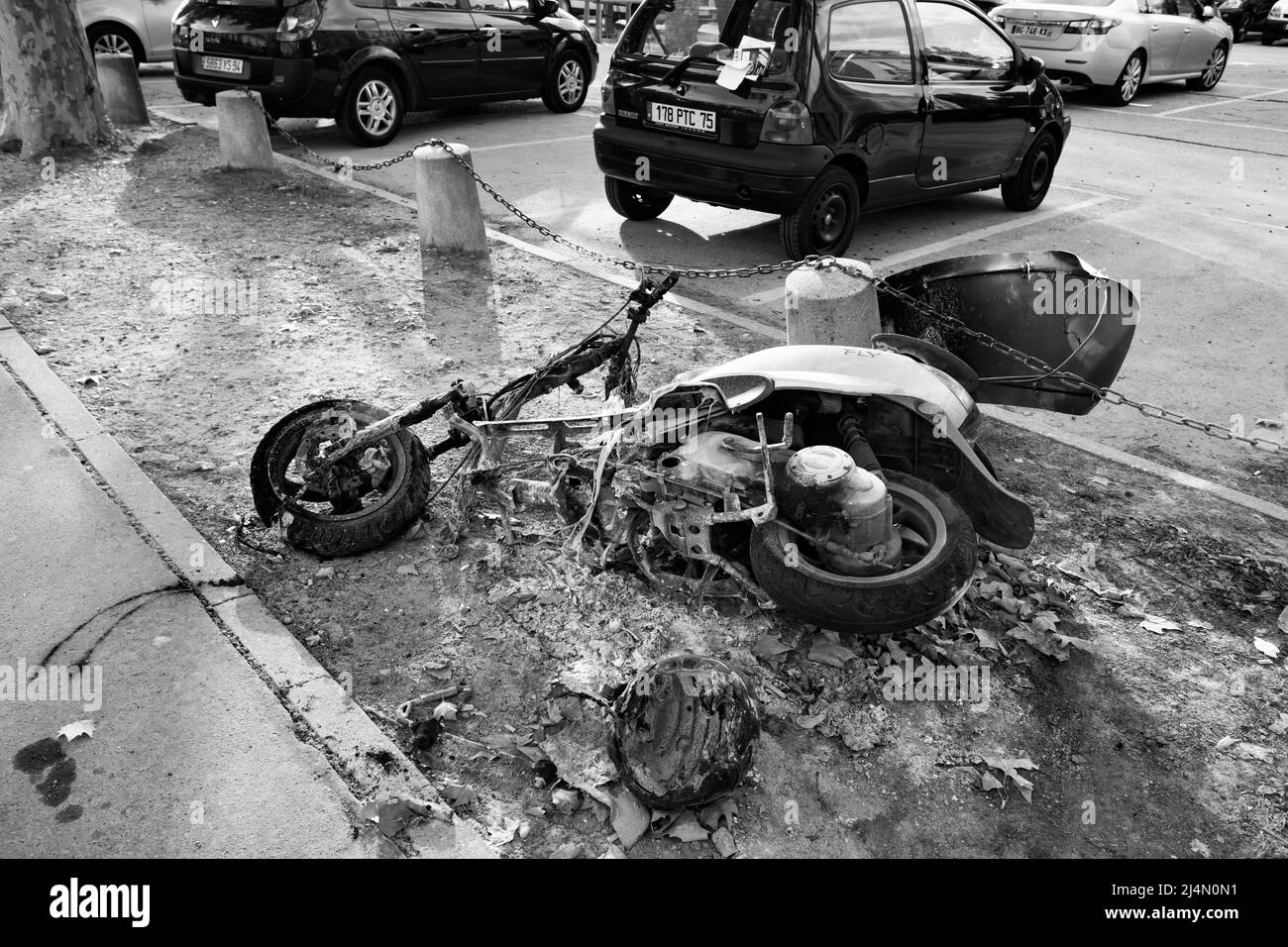 Paris, France - September 14, 2011: Burnt out motor scooter at car park. Black and white photography Stock Photo