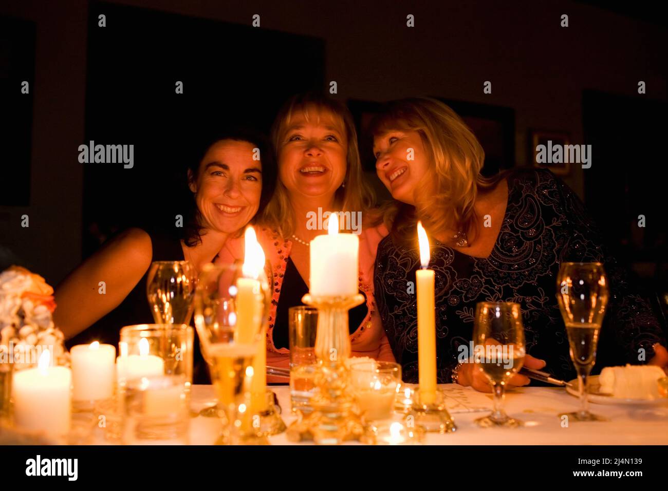 Three friends at the dinner table Stock Photo