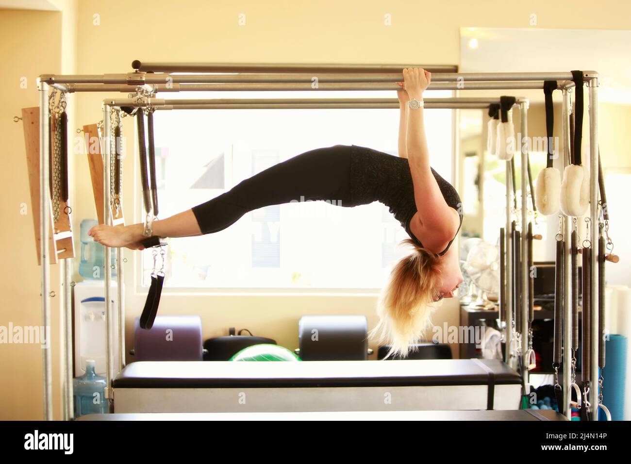 Young woman doing exercises on the 'cadillac', equipment specially designed  for advanced pilates training Stock Photo - Alamy