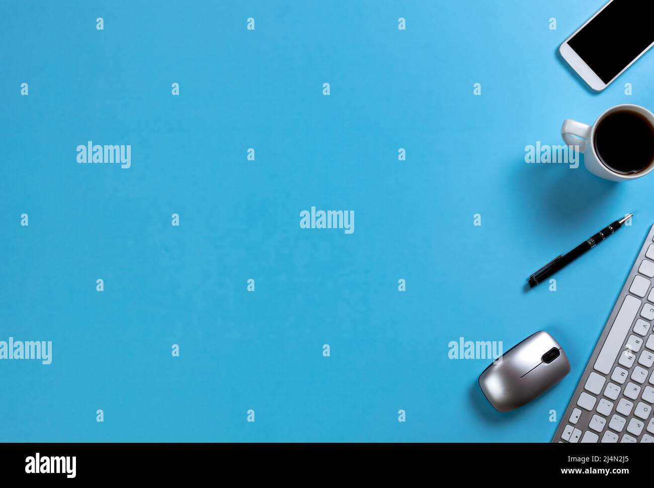 Blue office desk top with computer keyboard, cup of morning coffee and