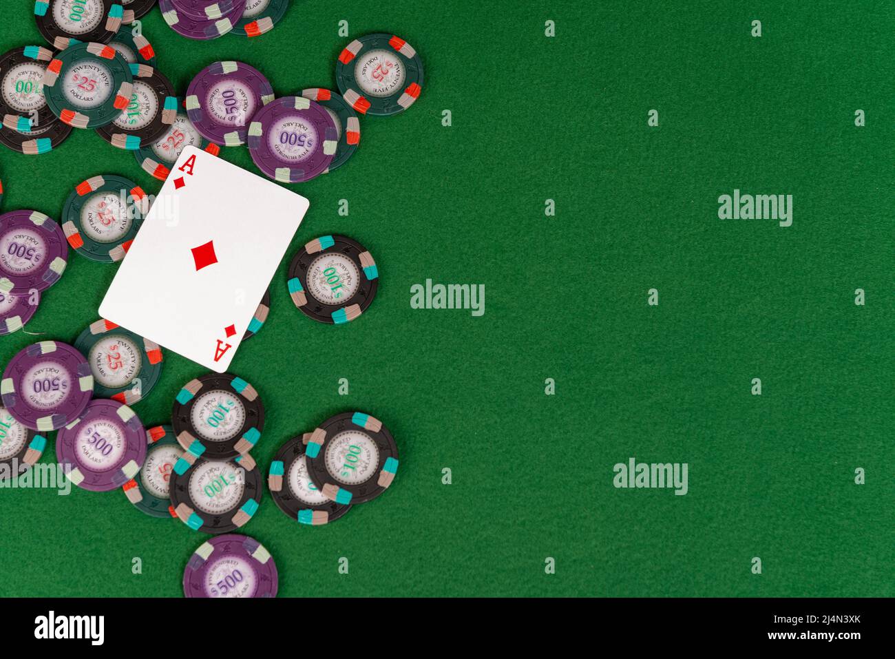 An ace of diamonds is pictured atop a pile of poker chips with copy space to the right. Stock Photo