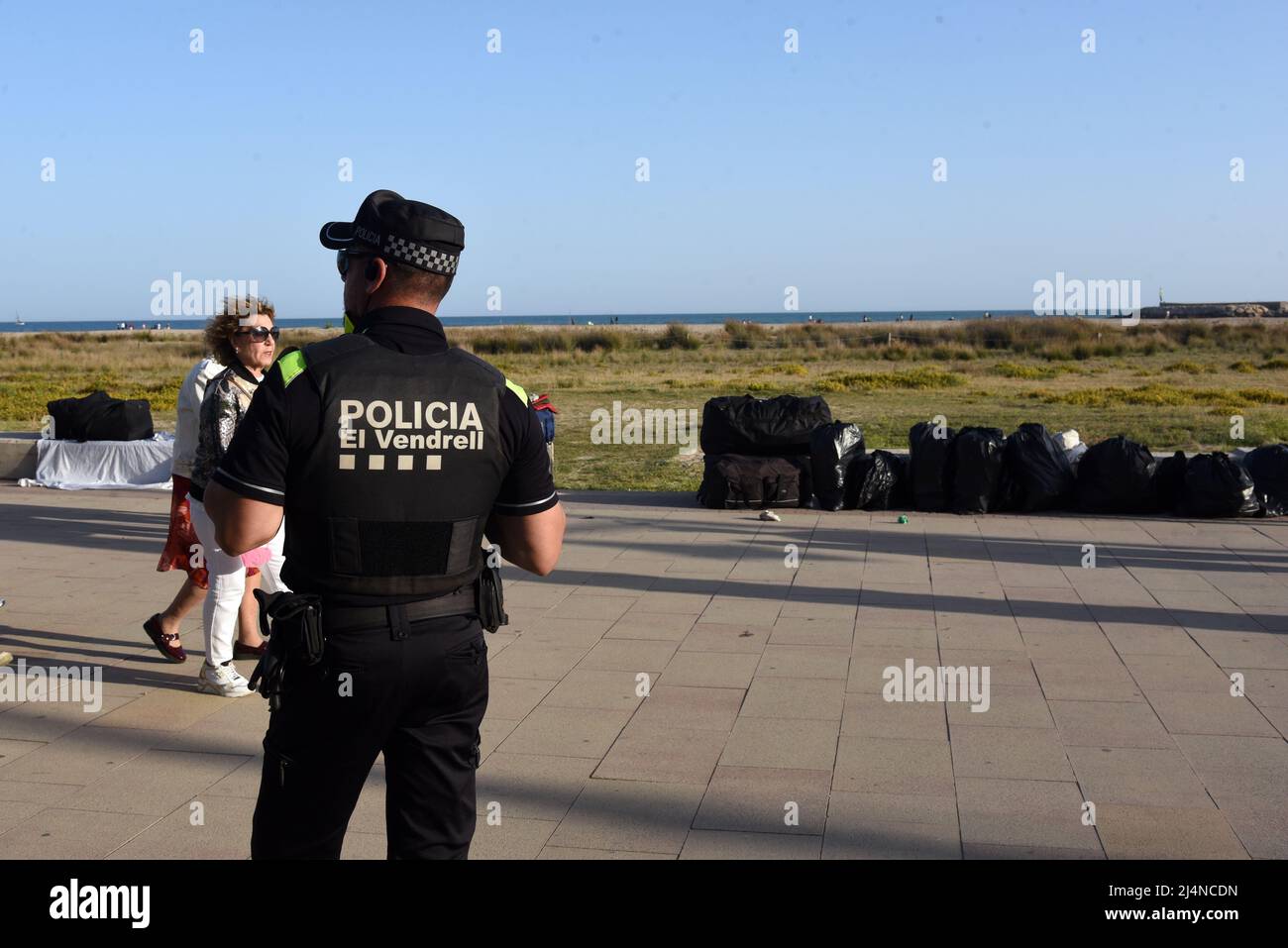 Vendrell, Spain. 16th Apr, 2022. A local police agent observes the products  collected in bags from illegal street vendors on Paseo Maritimo Street. The  Vendrell local police fights daily against the illegal