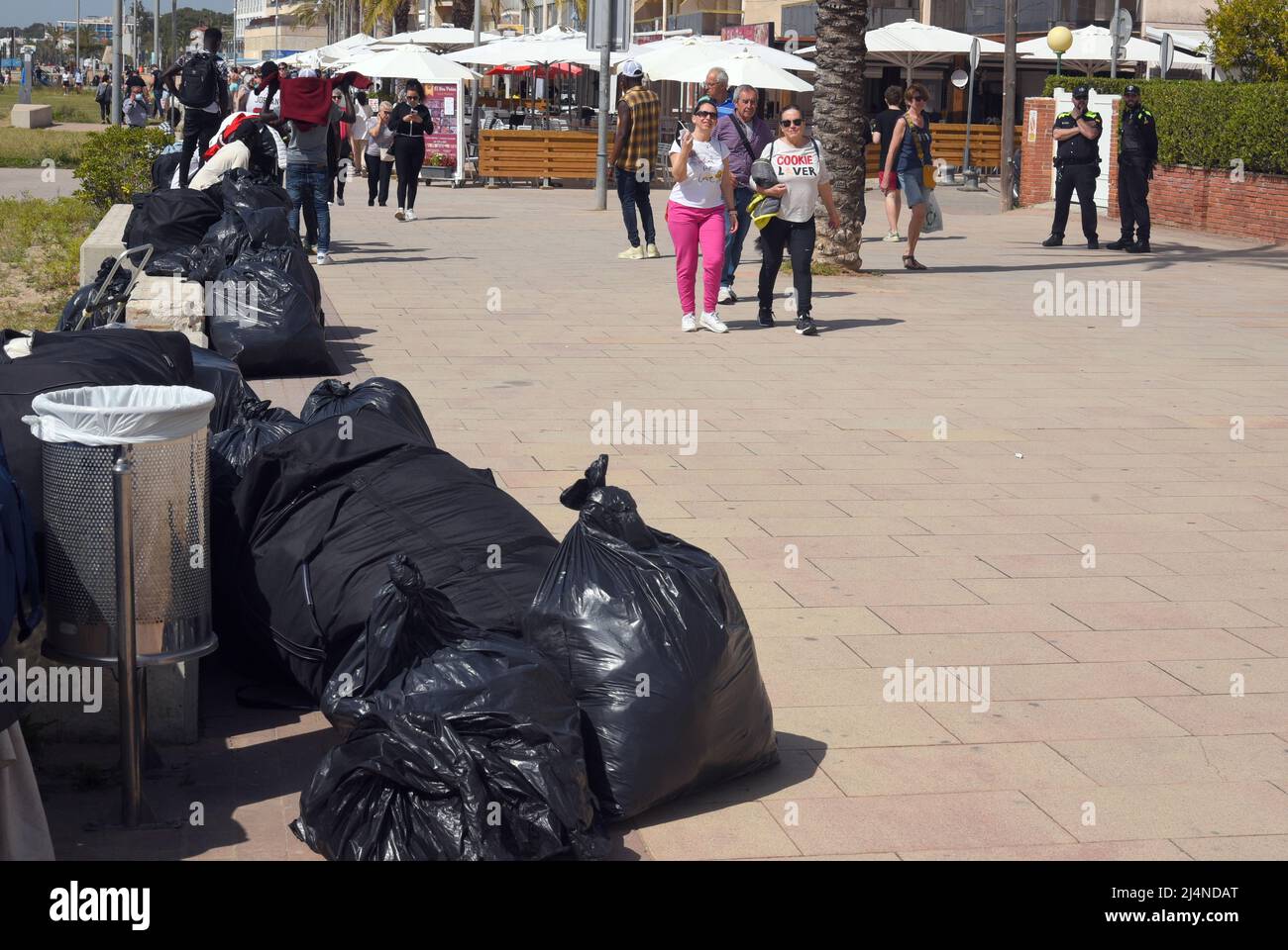 Vendrell, Spain. 16th Apr, 2022. Local police officers observe some vendors  who collect their products on the Paseo Maritimo Street. The Vendrell local  police fights daily against the illegal street vendors and