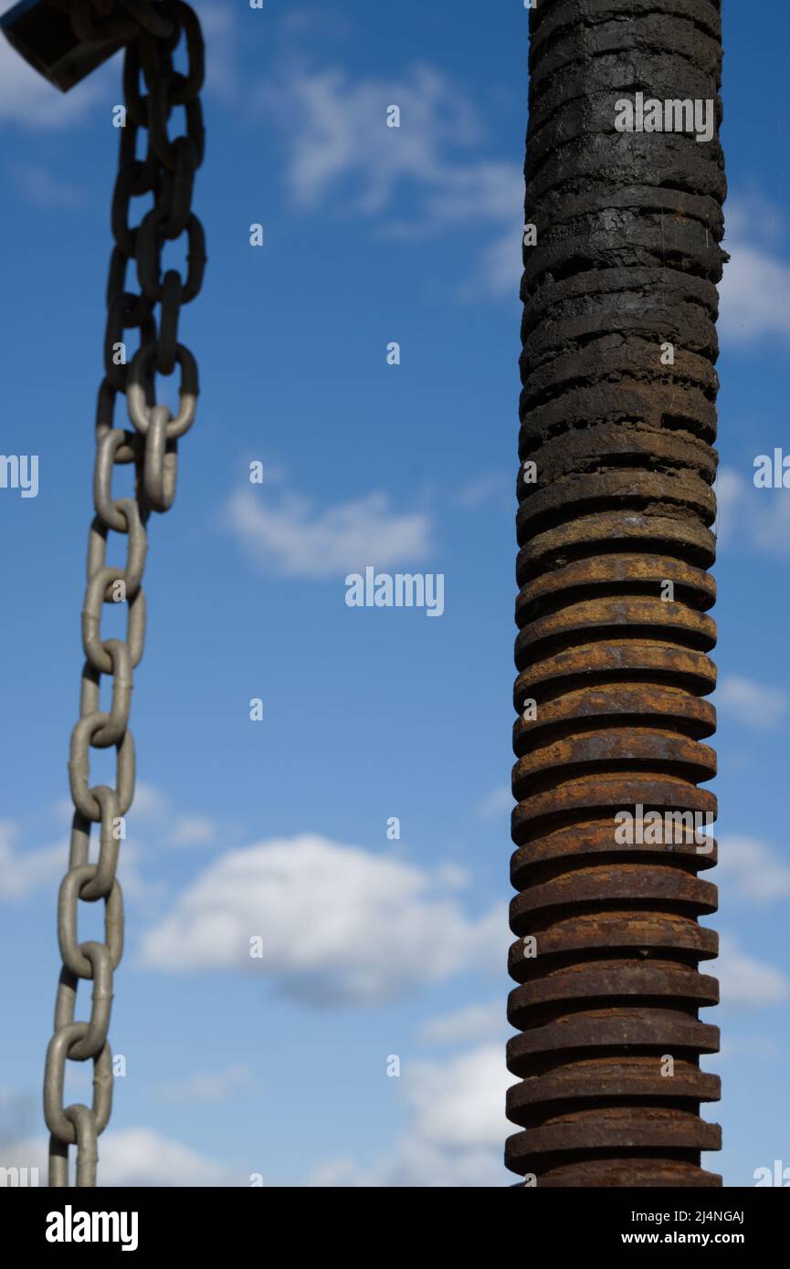 Metal chain and old, rusty, threaded iron pipe Stock Photo