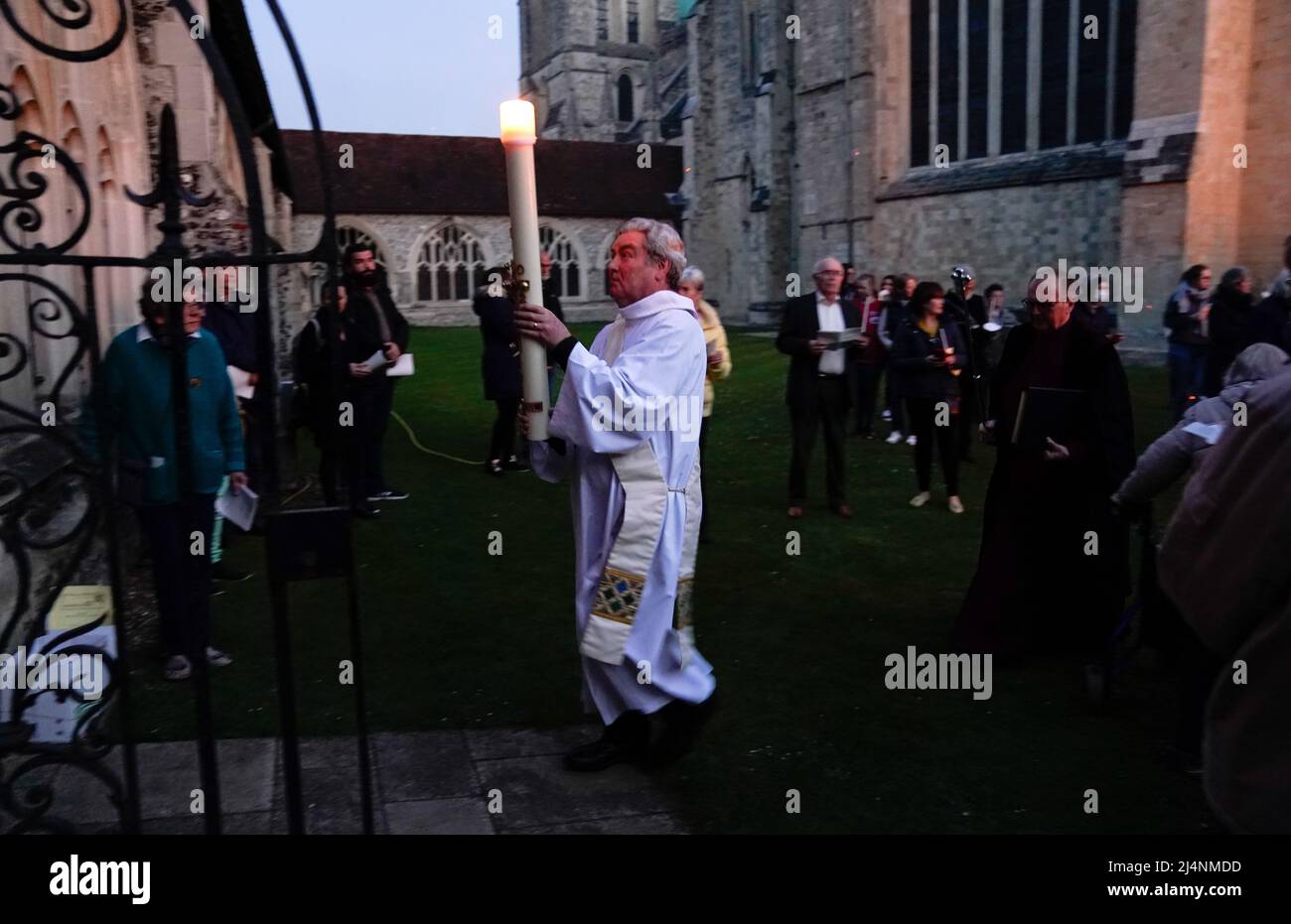 The Paschal candle is carried towards the cloisters after being lit during the Dawn Liturgy of Easter service at Chichester Cathedral. Picture date: Sunday April 17, 2022. Stock Photo