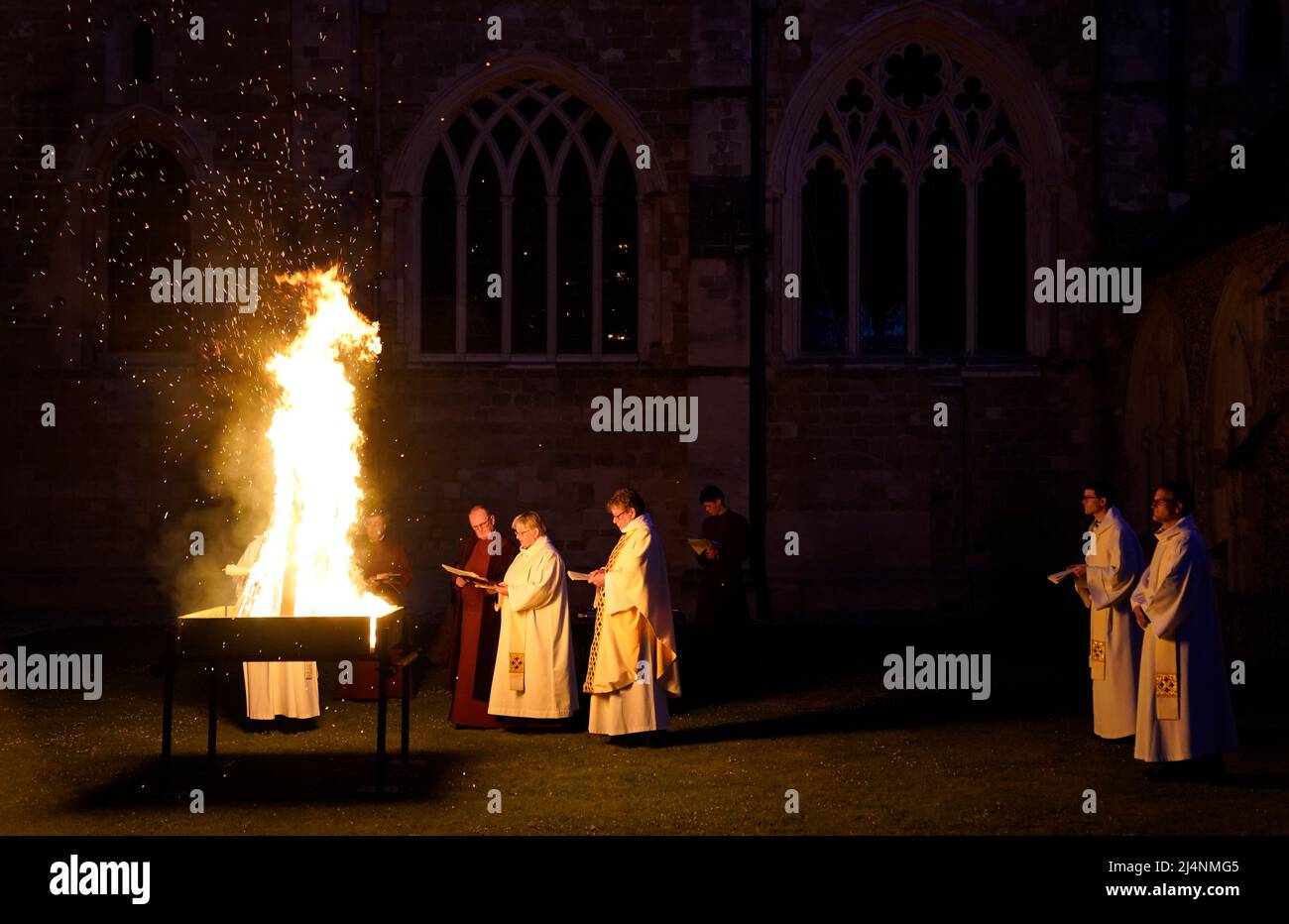 A reading is given next to a fire prior to the Paschal candle being lit during a Dawn Liturgy of Easter service at Chichester Cathedral. Picture date: Sunday April 17, 2022. Stock Photo