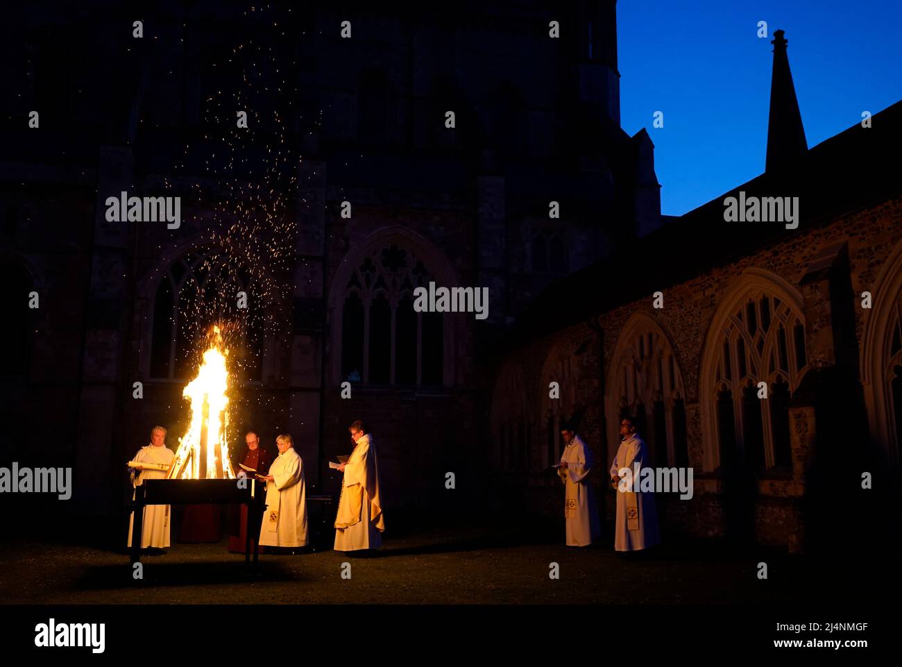 A reading is given next to a fire prior to the Paschal candle being lit during a Dawn Liturgy of Easter service at Chichester Cathedral. Picture date: Sunday April 17, 2022. Stock Photo