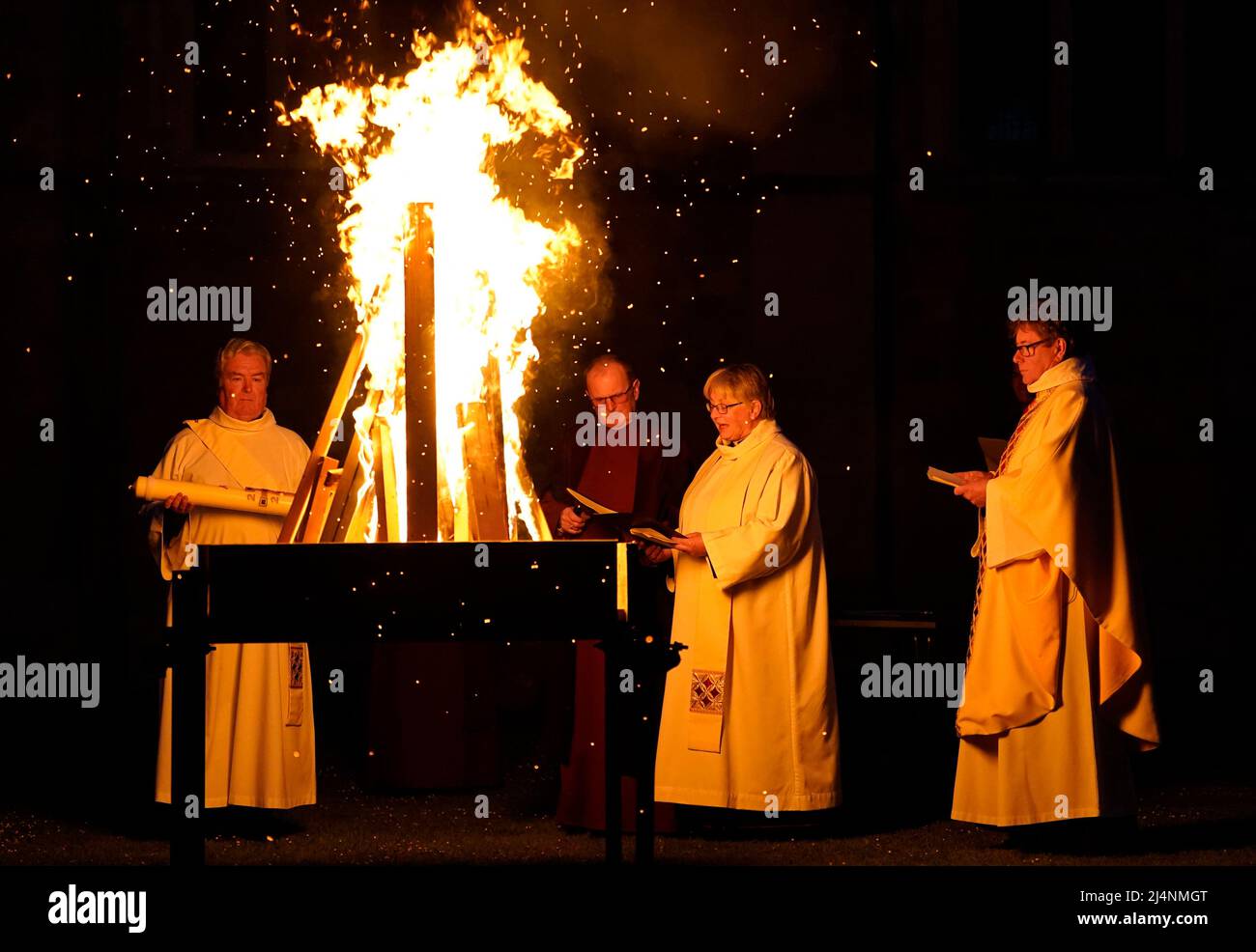 A reading is given next to a fire prior to the Paschal candle being lit during a Dawn Liturgy of Easter service at Chichester Cathedral. Picture date: Sunday April 17, 2022. Stock Photo