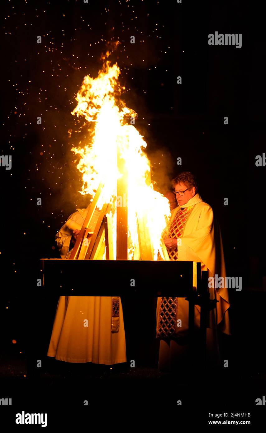 A reading is given next to a fire prior to the Paschal candle being lit during a Dawn Liturgy of Easter service at Chichester Cathedral. Picture date: Sunday April 17, 2022. Stock Photo
