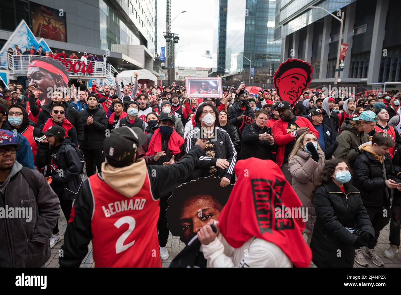 Fans watch and react as they watch 2022 NBA playoff game action between the Raptors and Philadelphia 76ers at a closed-off tailgate area outside the Scotiabank Arena known as Jurassic Park in