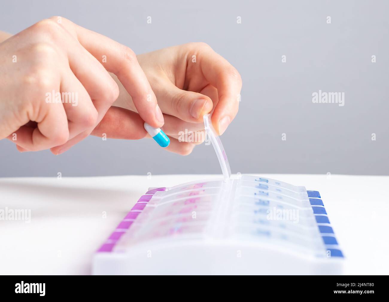Woman hand taking pill, vitamin from case, organizer. Sorting tablets for daily medication. Health care and diseases cure. High quality photo Stock Photo