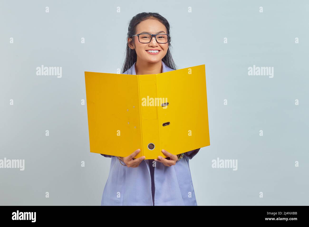Portrait of smiling young Asian business woman holding yellow folder ...