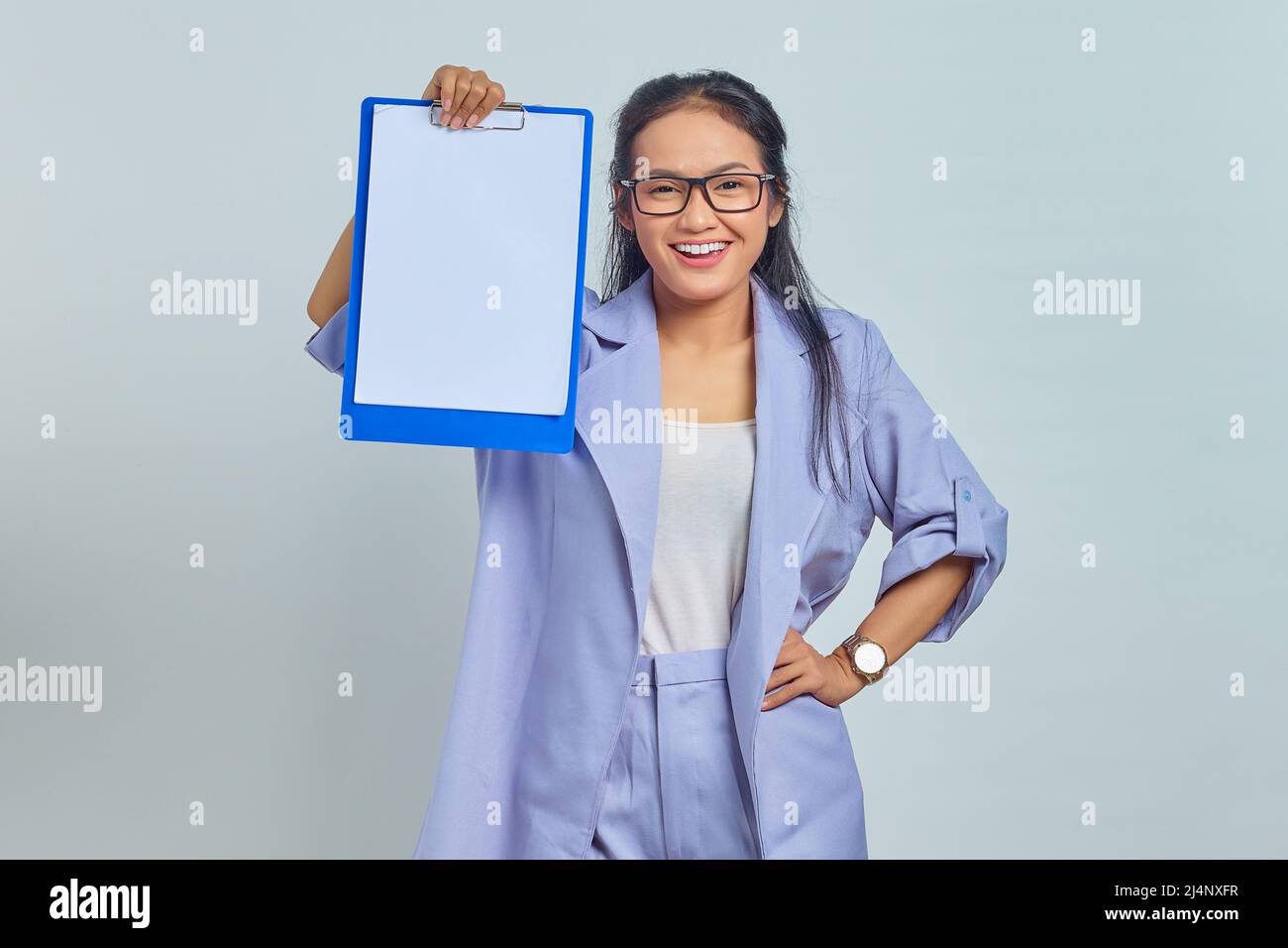 Portrait of smiling young Asian business woman in suit standing and ...