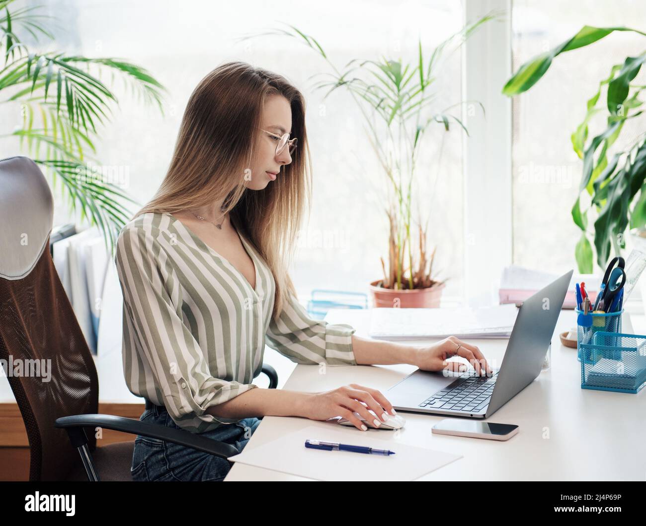 Young woman working on a computer in her office Stock Photo - Alamy