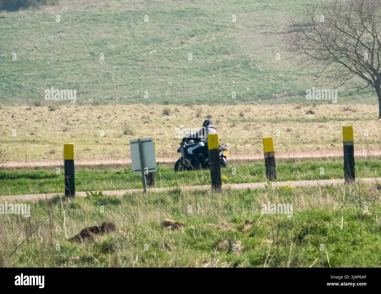 a motor cyclist (biker) riding their offroad motorbike along a stone