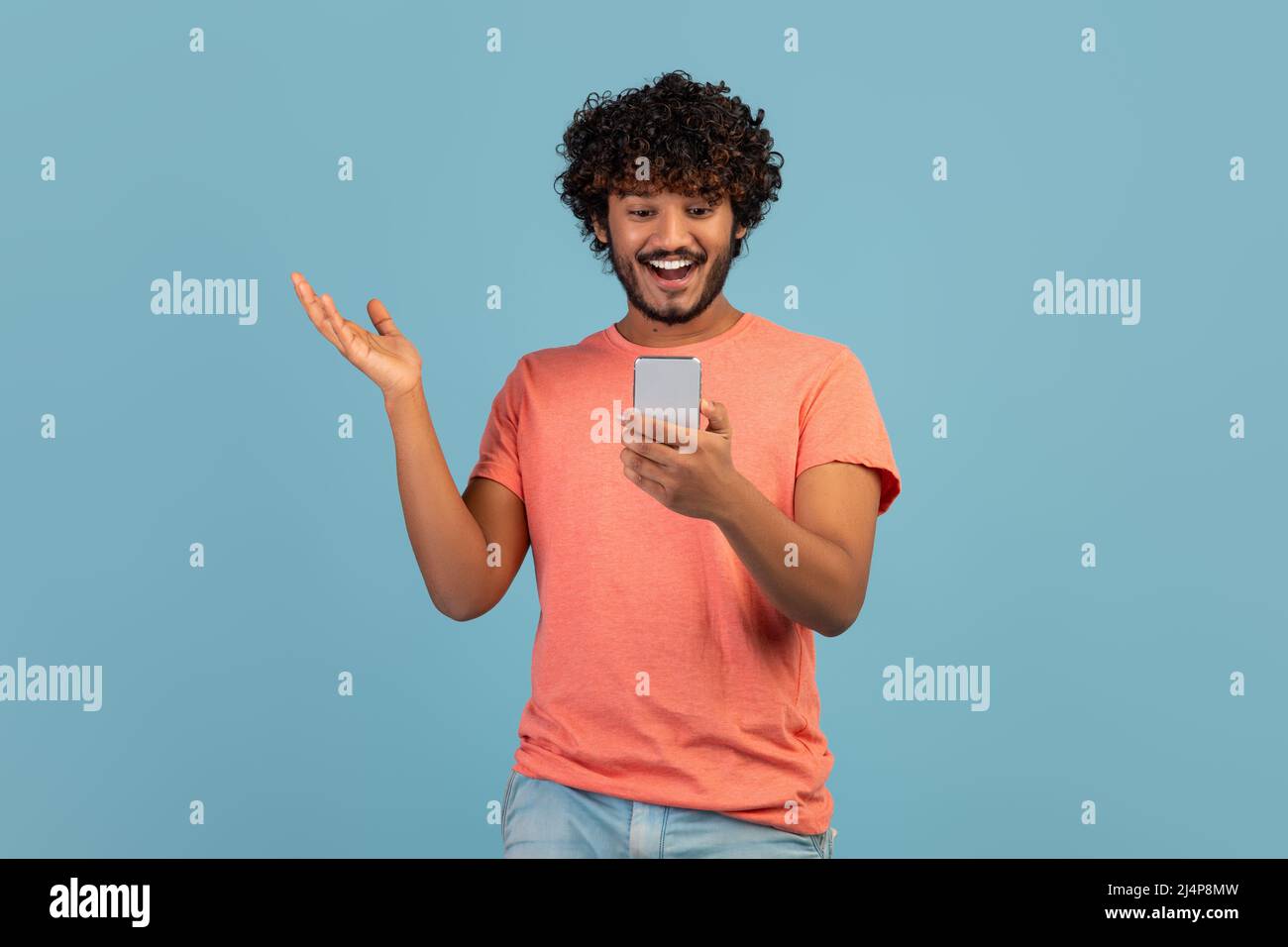 Emotional eastern guy enjoying newest mobile app Stock Photo
