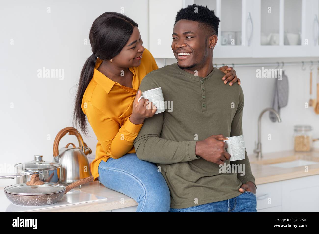Loving African American Couple Drinking Coffee Together In Kitchen ...