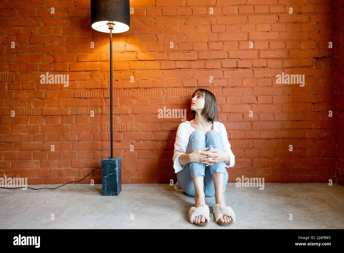 Woman sitting alone at home Stock Photo