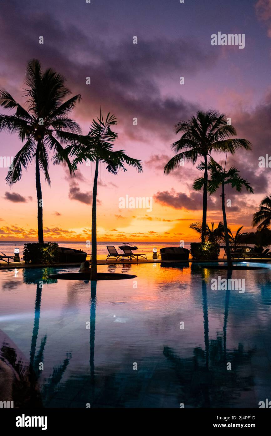 sunset tropical pool with palm trees, watching the sunset by the pool ...