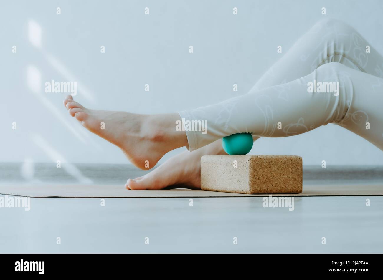 Calf muscle on therapy massage ball on cork block for myofascial release and hydration. Concept: self care practices at home, foot pain relief Stock Photo