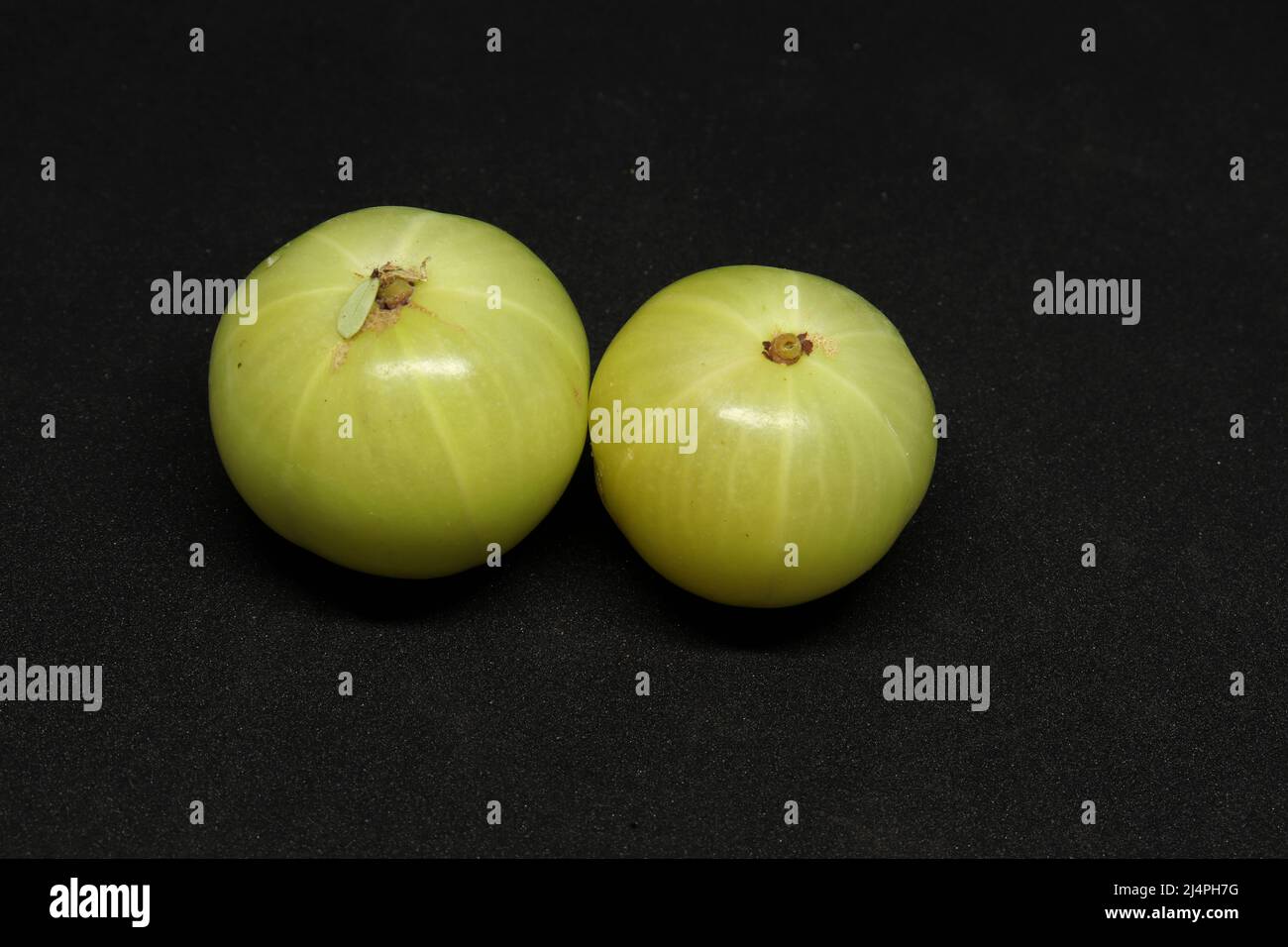 close up shot of two gooseberries, On a black background. Stock Photo