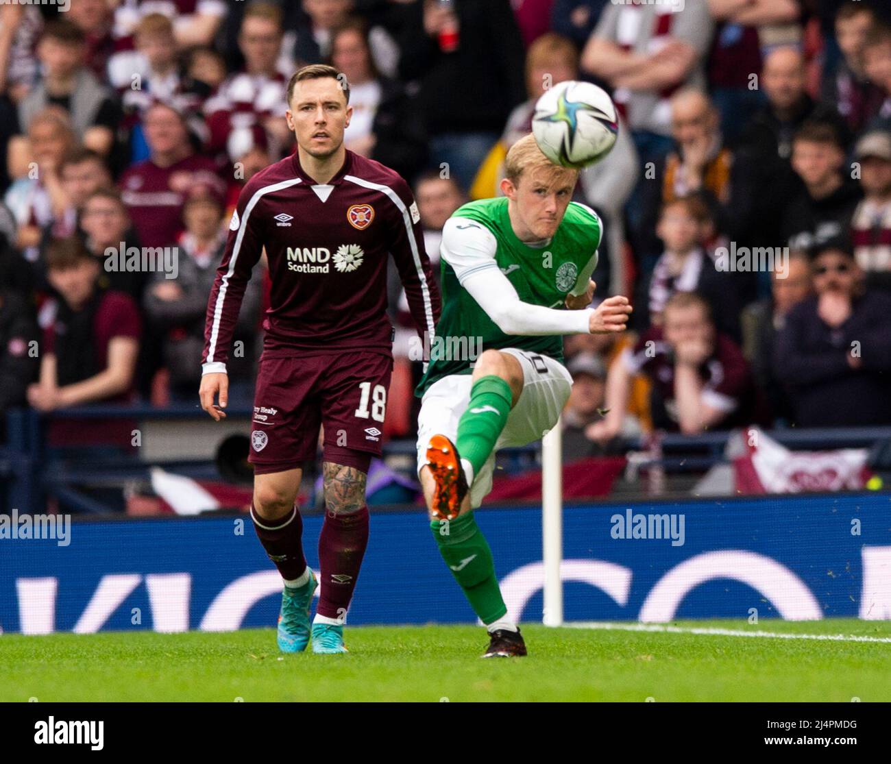 Glasgow, UK. 07th Apr, 2022. Scottish Cup semi final - Heart of Midlothian FC v Hibernian FC 07/04/2022 Pic shows: HibsÕ midfielder, Jake Doyle-Hayes, lobs the ball into the penalty area as HeartsÕ midfielder, Barrie McKay, looks on as Hearts take on Hibs in the Scottish Cup semi final at Hampden Park, Glasgow Credit: Ian Jacobs/Alamy Live News Stock Photo